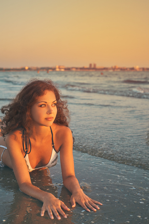 Young beautiful slim tanned lying woman in bikini on the beach. Summer holidayの写真素材