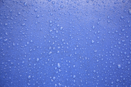 Water drops on blue, detail of a wet blue surface water, rain in the cityの写真素材