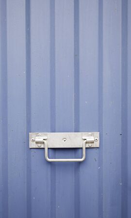 Blue metal door, detail of a wall decorated with metal handle, textured backgroundの写真素材