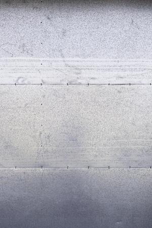 Metal dirty wall, detail of a metallic background shabby sheet metal plates, textured backgroundの写真素材