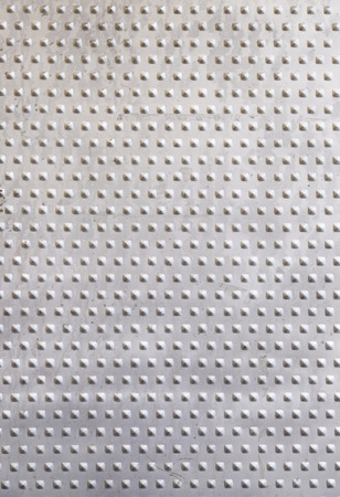 Embossed metallic background, detail of a textured metal wall, protection and decorationの写真素材