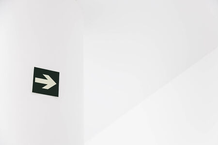 Green Arrow departure, detail of an arrow on a white wall, and safety information