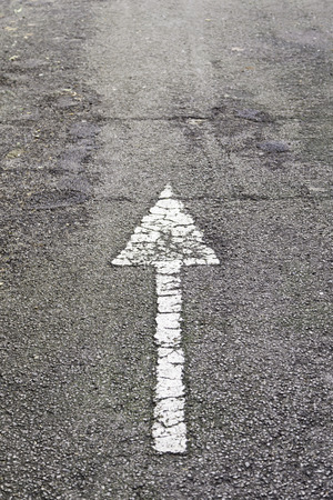 Arrow direction on asphalt, detail of an arrow of indexation on a highway, road informationの写真素材