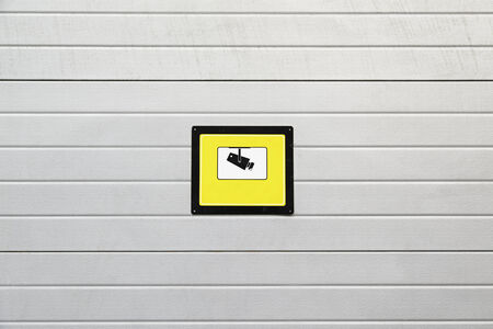 Signal surveillance camera, detail of a wall with a plate of surveillance information in the cityの写真素材