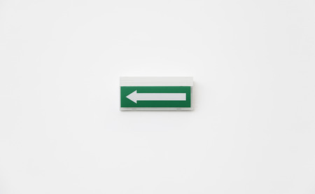 Green Arrow departure, detail of an arrow on a white wall, and safety informationの写真素材