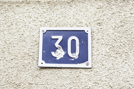 Number thirty on a wall, detail of a number of information on a wall, even numberの写真素材