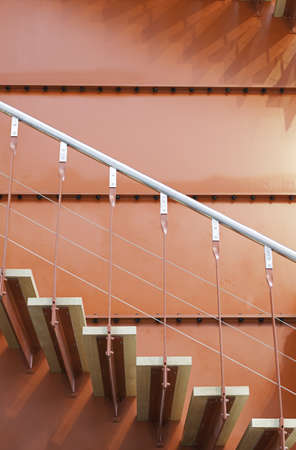 Wooden stairs and red metal, detail of a staircase inside an industrial buildingの写真素材