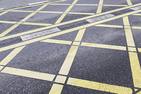 Yellow traffic sign on asphalt, detail of a sign on a road in cityの写真素材