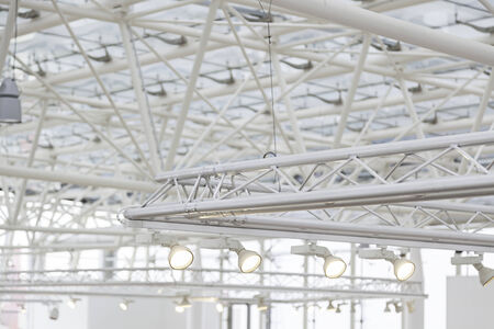 Focuses on an interior roof detail of an electric lighting on a ceiling in an industrial buildingの写真素材