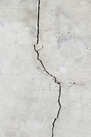 Cracked cement wall, detail of a wall damaged by the passage of time, outside facadeの写真素材