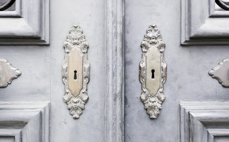 Wooden door with metal knockers, door detail of a decorated, safety and security