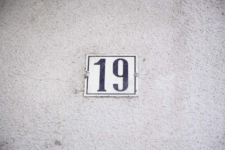 Number nineteen on the wall of a house, detail of an information number, odd number