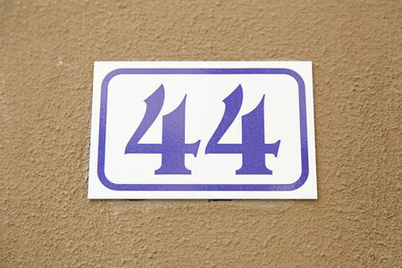 Number forty-four on the wall of a house, detail of a number of information, even numberの写真素材