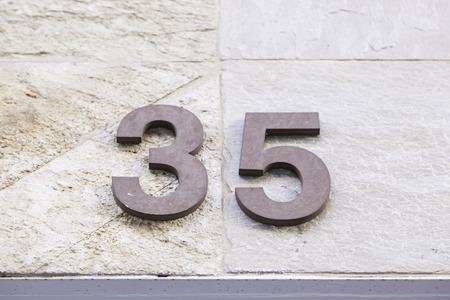 Number thirty-five in a wall, detail of a number of information, odd numberの写真素材