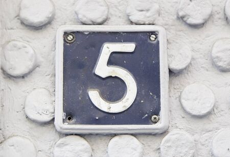 Number five on the wall of a house, detail of a number of information, odd numberの写真素材