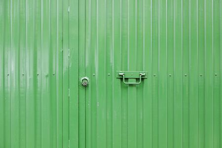 Green metal door, detail of a closed door, protection and decorationの写真素材