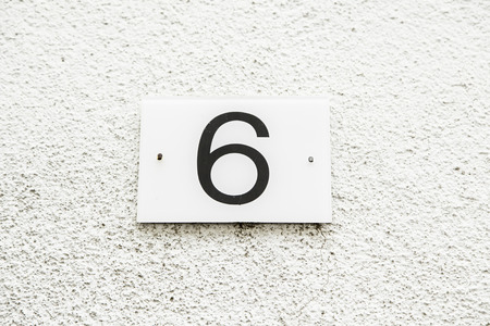 Number six on the wall of a house, number of information, even numberの写真素材