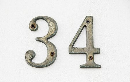 Number thirty-four on a wall, detail of an information number, even numberの写真素材