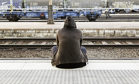 Woman sitting in a train station, detail waiting to grab a trainの写真素材