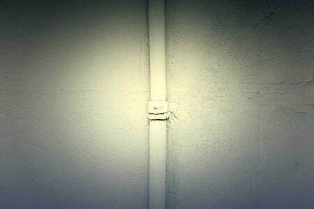 White wall with a pipe, detail of a textured wallの写真素材