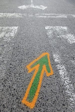 Arrow painted on the asphalt, detail of information and indication, road safetyの写真素材