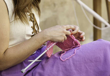 Young woman knitting clothes wool, detail of old tradition to make clothes