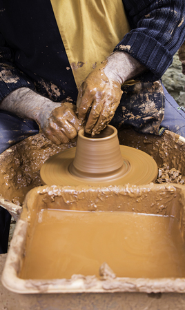 Hands of man working and shaping clay, potter in pottery, craft detail, creationの写真素材