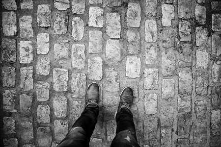 Feet on cobblestones, detail of person in the city, tourism and explorationの写真素材