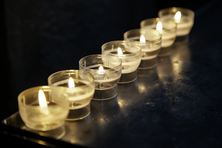 Candles lit in a church, detail of medieval city in Belgiumの写真素材
