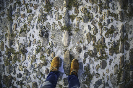 Feet with boots on the street, detail of modern footwear, cold in winterの写真素材