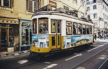 LISBON, PORTUGAL - April 19, 2014: Street view with famous old tourist tram full of people during the sunny day in Lisbon city, Portugalのeditorial素材