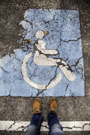 Disabled sign on the asphalt, detail of social integration, facilities for the disabled