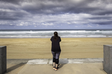 Detail of woman walking and contemplating the beach, vacations and relaxationの写真素材
