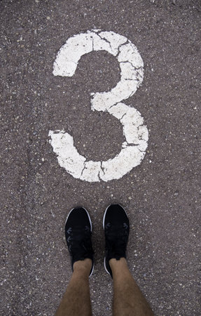 Detail of feet above the number three on a running trackの写真素材