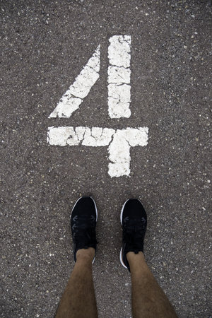 Detail of feet above the number four on a running trackの写真素材