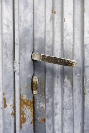 Detail of an old metal handle to open an abandoned doorの写真素材