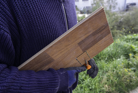 Detail of young man cutting and working with wood, carpenterの写真素材