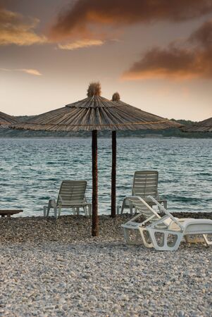 umbrellas and chairs on the beach at sunset in Croatiaの写真素材