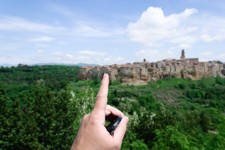 index finger indicating the country of Pitigliano in Tuscany in the backgroundの写真素材