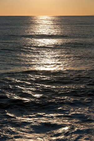 reflections on the waves of the sea at sunsetの写真素材