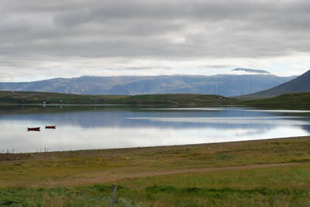 River with boats between mountains of Akureyri in Icelandの写真素材
