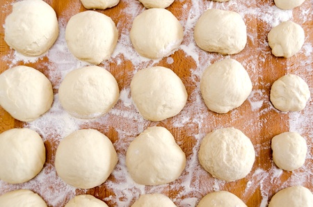 portions of pizza dough on wooden cutting board