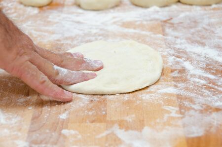 hands of the cook kneading dough pizzaの写真素材