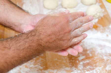 hands of the cook while preparing the pizza doughの写真素材