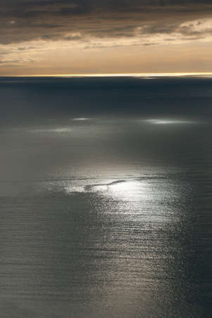 sunset with light reflections on the sea in Genoa, Italyの写真素材