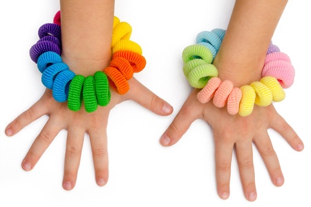 hands of a little girl with hair bands of many colorsの写真素材