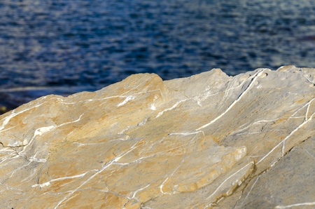 yellow rock on the blue sea in Genoaの写真素材