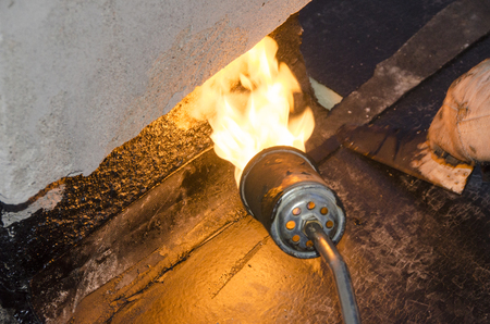 During welding flame of a waterproofing membrane on a roofの写真素材