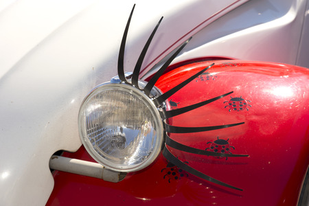 headlight of a car adorned with eyelashes like an eyeの写真素材