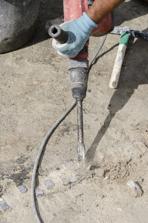 worker while splitting the concrete with the jackhammer during the renovation of a roofの写真素材